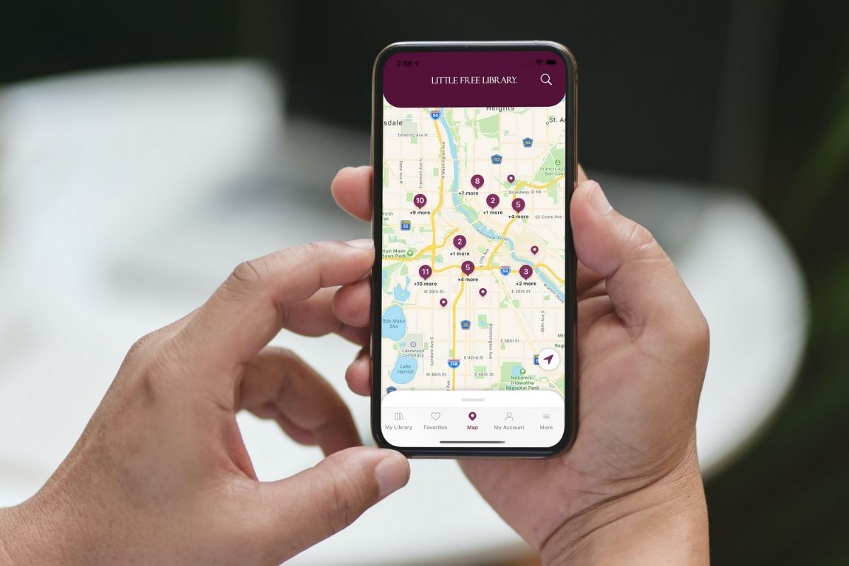 Person holding iPhone using the Little Free Library app